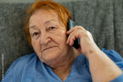 Wallpaper Mural elderly woman talking on smartphone while sitting on couch Torontodigital.ca