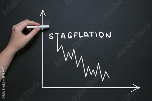 stagflation garfik, hand draws on the blackboard with chalk, the word stagflation, market fall and inflationary risks with the concept of a stifling economy photo