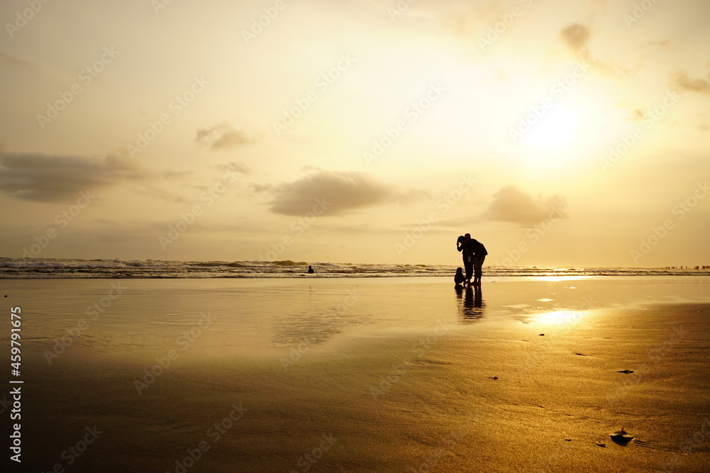 Obraz premium silhouette of people under the moment of sunset on parangtritis beach, Yogyakarta
