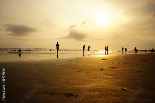 Selective low angle shot of silhouettes of beachgoers enjoying the sunset at Parangtritis beach  Yogyakarta