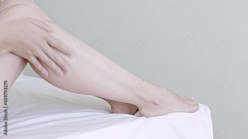 Young woman moisturizing skin by applying cream, lotion on her legs at home, body care concept Young woman moisturizing skin by applying cream, lotion on her legs at home, body care concept