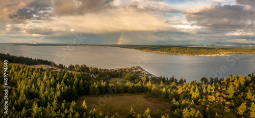 Rainbow Forming Off the West Side of Lummi Island, Washington. Aerial sunset drone shot of Hale Passage with a rainbow off in the distance in this Pacific Northwest view. 