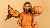 Surprised Halloween girl. Woman with witch hat and pumpkin. Pumpkins party celebration.
