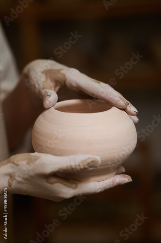 Close up of potters hands in clay and with a new bowl