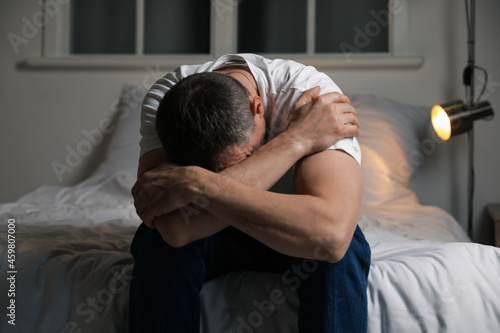 Depressed mature man in bed...