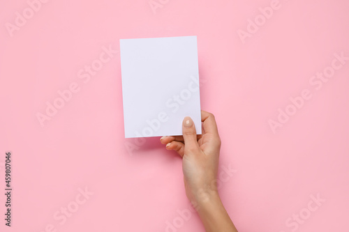 Female hand with blank card on color background