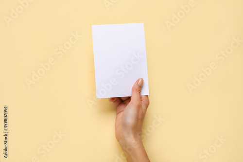 Female hand with blank card on color background
