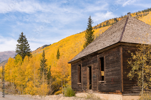 Abandoned building among the yellow aspen trees in the Sun Juan Mountains of ...