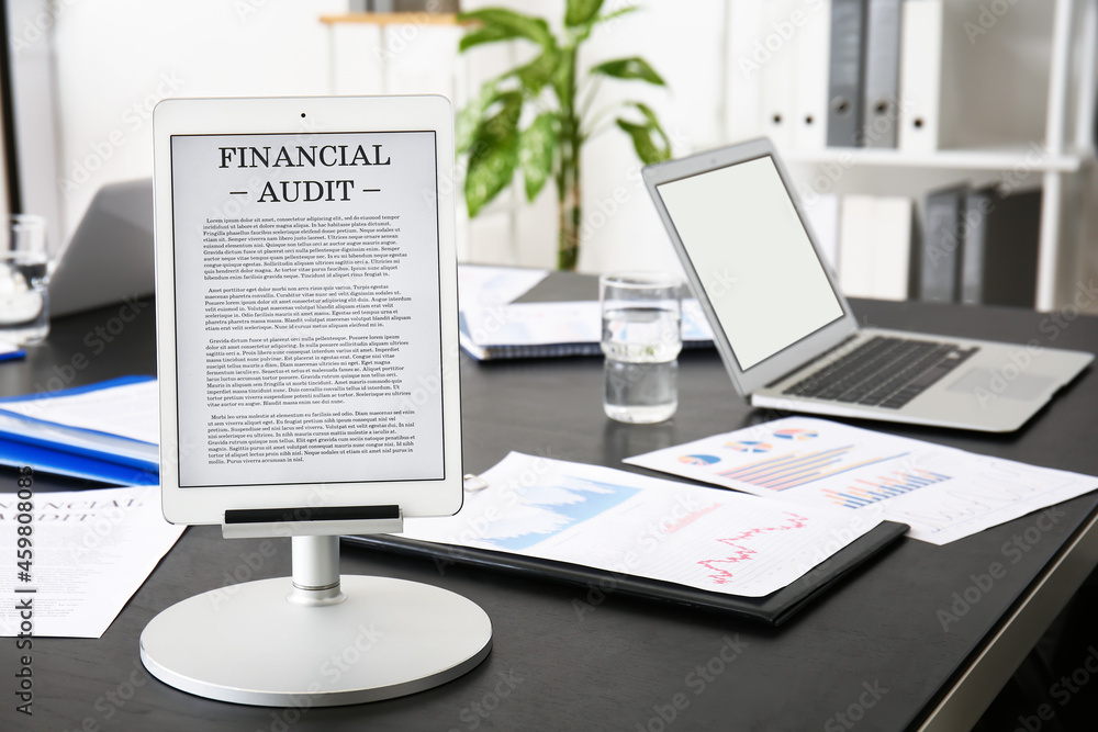 Tablet computer with financial audit on table in office Tablet computer with financial audit on table in office