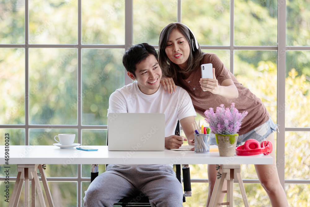 Young attractive Asian couple taking a selfie together in living room with glass windows background. Concept for love and couple relationship Young attractive Asian couple taking a selfie together in living room with glass windows background. Concept for love and couple relationship