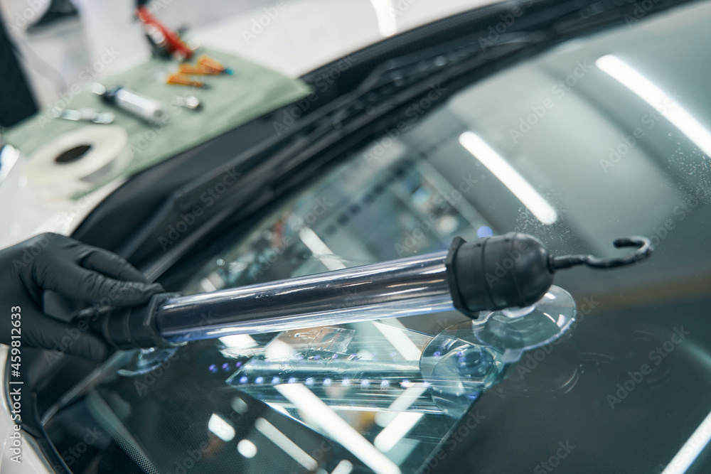 Repair cracked car windshield. Ultraviolet lamp for final elimination Repair cracked car windshield. Ultraviolet lamp for final elimination