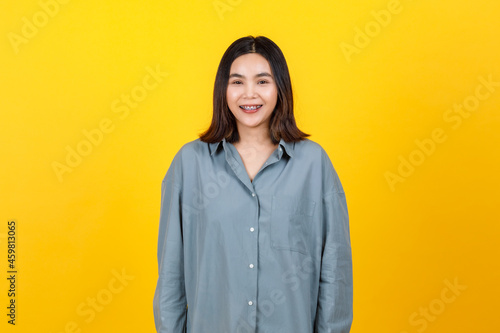 Lovely young Asian girl with braces standing and smiling to camera with happy and self-confident © Bangkok Click Studio