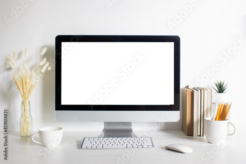 A mock up computer with blank screen and working items on table. 