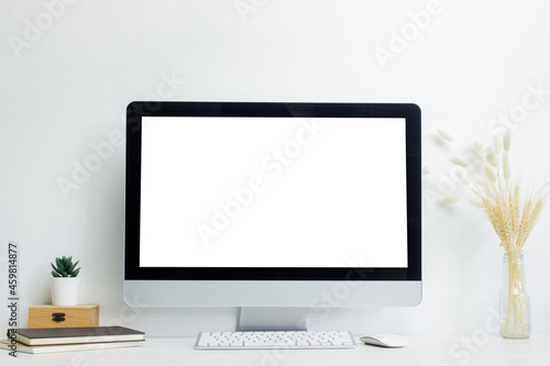 A mock up computer with blank screen and working items on table. 