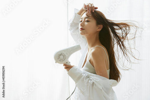 髪の毛を乾かす若い女性 photo
