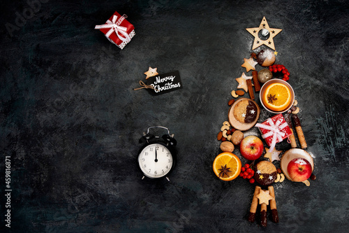 Christmas tree made of food on dark background.