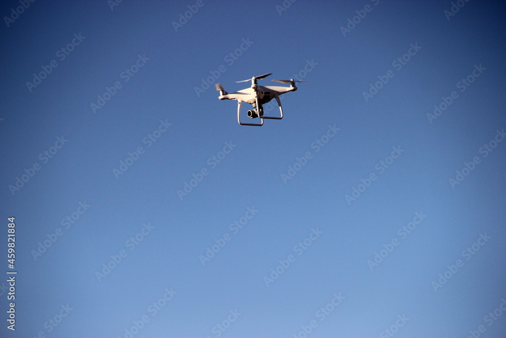 Quadcopter flying in the blue morning sky. Drone in the air. Quadcopter flying in the blue morning sky. Drone in the air.
