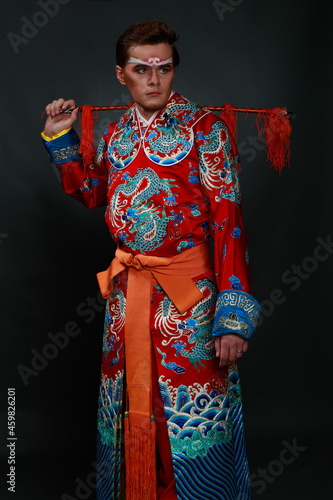 Chinese traditional warrior male costume at studio over grey background. Handsome man wearing national costume in Beijing, China