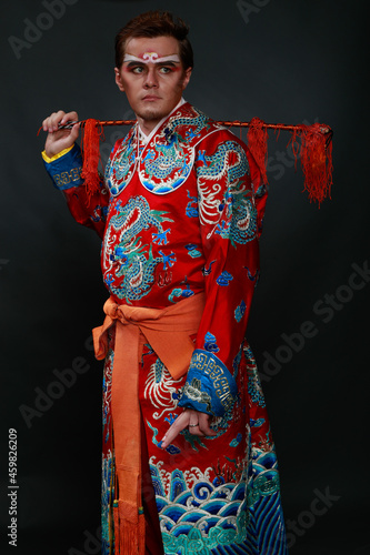 Chinese traditional warrior male costume at studio over grey background. Handsome man wearing national costume in Beijing, China