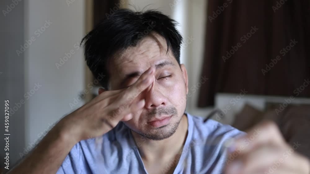 Asian man taking off glasses, feeling eyestrain, Tired Exhausted Eye Pain And Ache