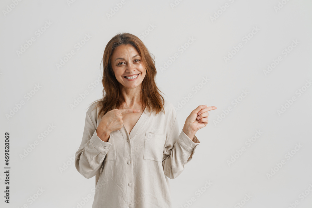 European ginger woman smiling and pointing fingers aside European ginger woman smiling and pointing fingers aside