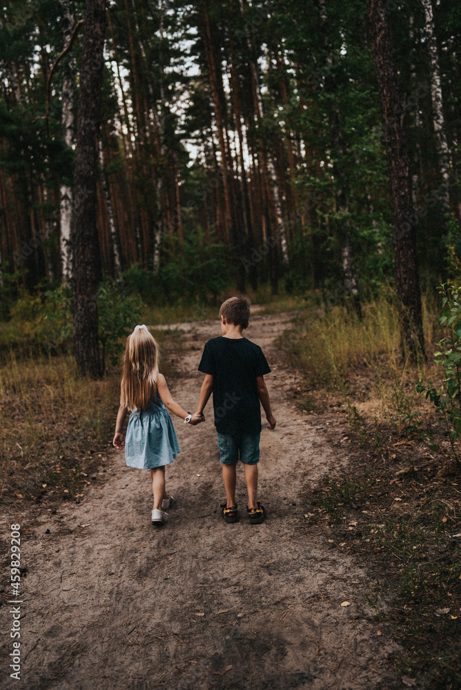 girl and boy holding hands in the forest girl and boy holding hands in the forest