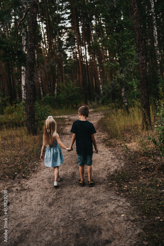 girl and boy holding hands in the forest