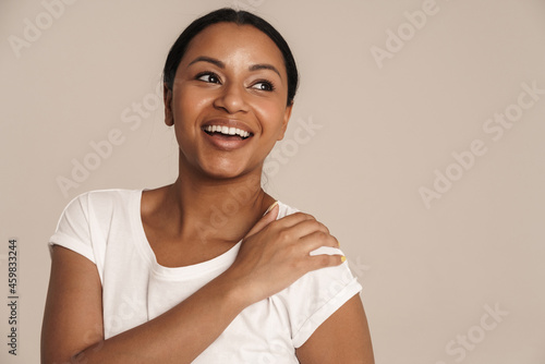 Young black woman wearing t-shirt laughing and looking aside © Drobot Dean