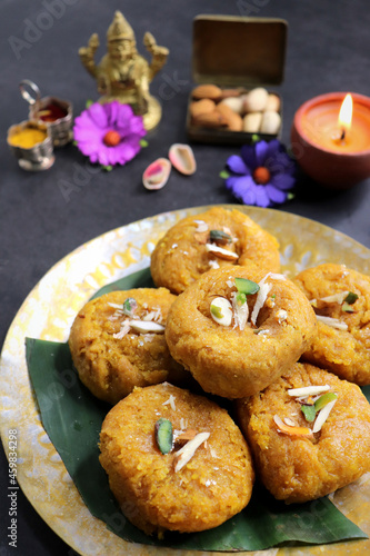 Indian traditional sweet balushahi served on a metal plate over black background. Also known as Balsaahi, badushah is a sweet food served on a Brass plate over moody background. Copy space. photo