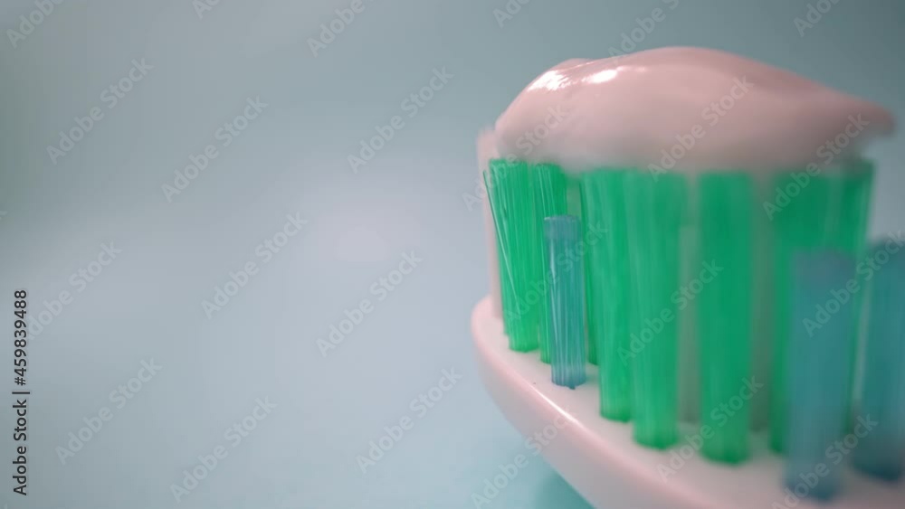 Extreme macro video filming, toothbrush on a blue background in motion, toothpaste on the brush. Forward movement, Close-up. Extreme macro video filming, toothbrush on a blue background in motion, toothpaste on the brush. Forward movement, Close-up.