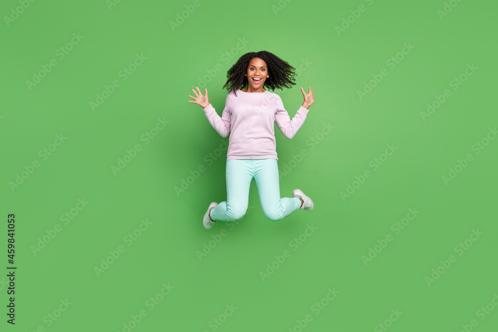 Full size photo of cool young brunette lady jump wear pullover pants shoes isolated on blue background Full size photo of cool young brunette lady jump wear pullover pants shoes isolated on blue background