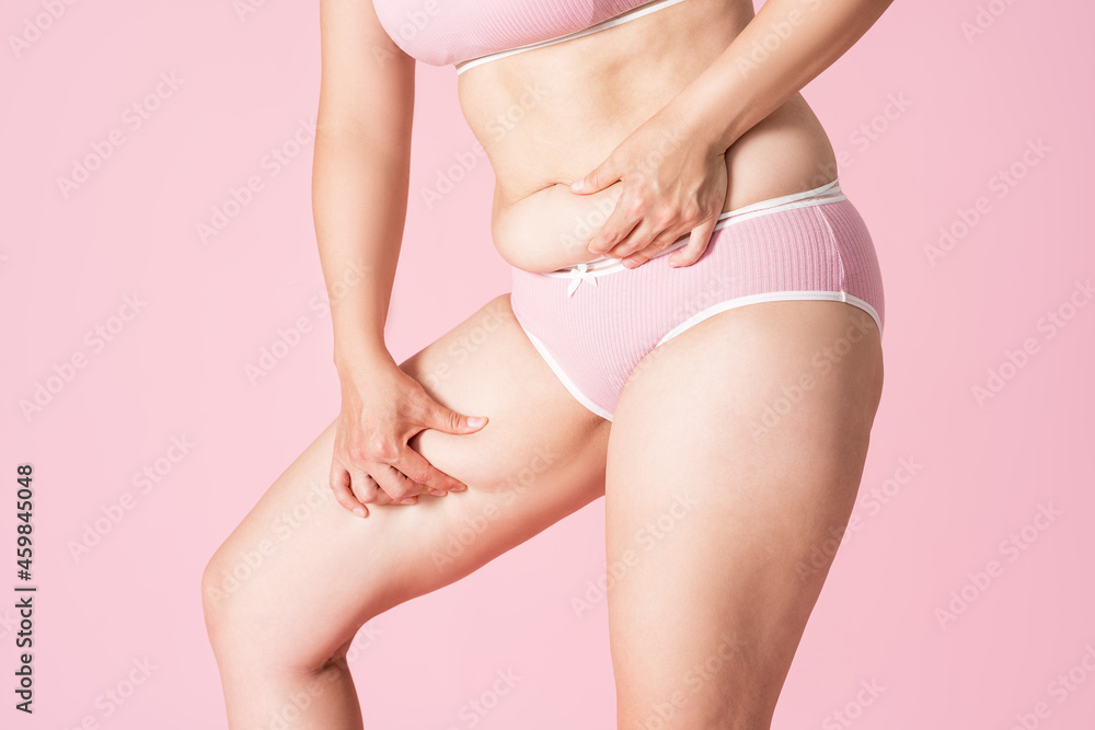 Fat woman in underwear on pink background, overweight female body