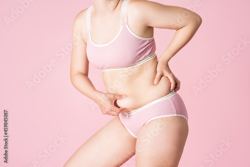 Tummy tuck, flabby skin on a fat belly, plastic surgery concept