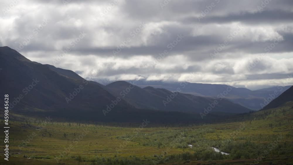 Mountains and green fields. Gray sky, storm clouds. Accelerated shooting, time-lapse. Mountains and green fields. Gray sky, storm clouds. Accelerated shooting, time-lapse.