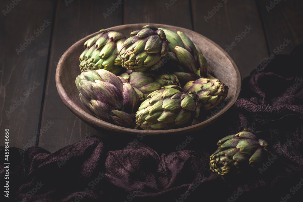 Obraz premium Fresh artichoke on the dark,wooden background. Ingredients of Mediterranean cuisine, rustic style 