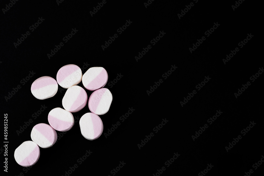 Arrow from marshmallow candies on a black background. Close-up Arrow from marshmallow candies on a black background. Close-up