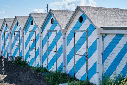 A colourful row of brightly coloured beach huts on the promenade.