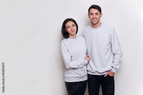 Happy couple standing embraced and smiling on white background. Copy space.