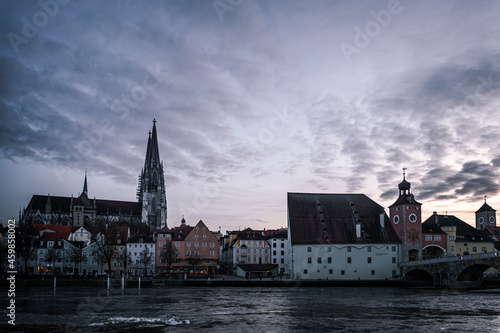 Fototapeta Naklejka Na Ścianę i Meble -  View from the Danube on the Regensburg Cathedral and Stone Bridge with lights in Regensburg in the evening, Germany