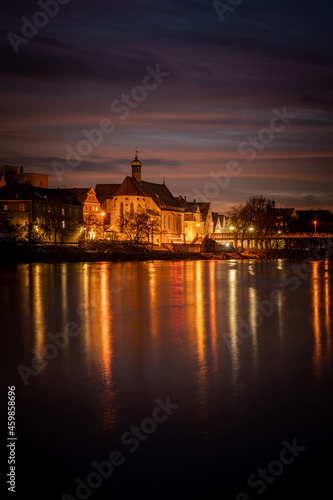 View from the Danube on the Regensburg Cathedral and Stone Bridge with lights in Regensburg in the evening, Germany © CreativeImage