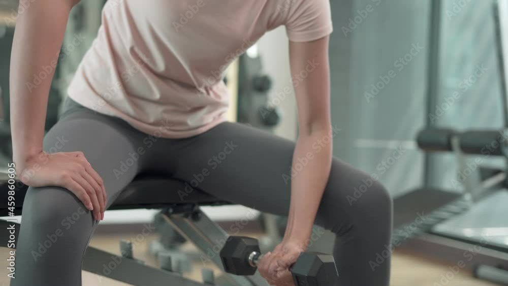 Concept of exercise on fitness for healthy.Women exercise by lifting weights to strengthen the muscles. Women exercise in fitness to lose weight by dumbbell. Concept of exercise on fitness for healthy.Women exercise by lifting weights to strengthen the muscles. Women exercise in fitness to lose weight by dumbbell.