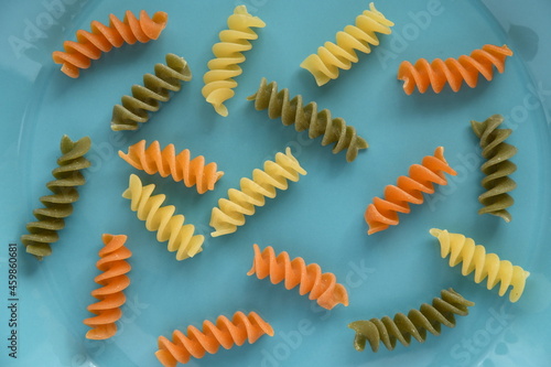 Tricolore fusilli Italian pasta on light blue background.