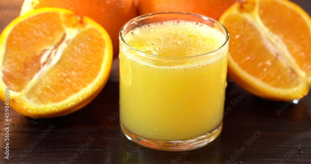 Pouring orange juice from glass jar into glass. Close up glass of fresh orange juice. Preparing healthy breakfast from natural ingredient. Homemade fruit juice on table. Organic vitamin drink Pouring orange juice from glass jar into glass. Close up glass of fresh orange juice. Preparing healthy breakfast from natural ingredient. Homemade fruit juice on table. Organic vitamin drink