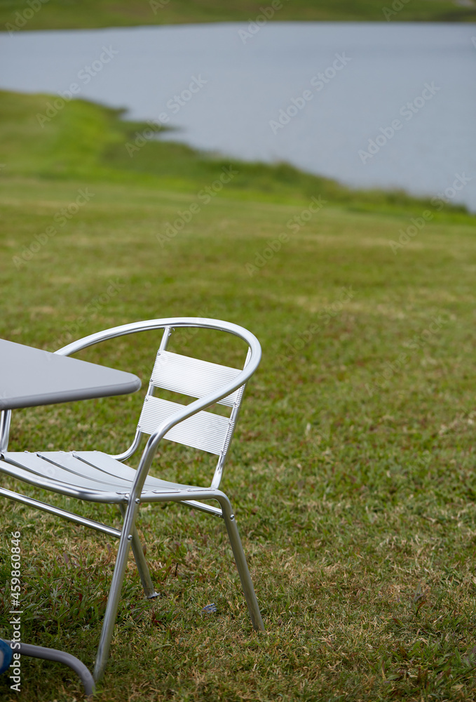 Close-up of outdoor leisure tables and chairs by the lake in the outdoor grass Close-up of outdoor leisure tables and chairs by the lake in the outdoor grass