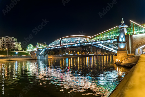 Evening view of the illuminated Bogdana Khmelnitsky Bridge (Kiev pedestrian bridge) - a pedestrian bridge across the Moskva River, which connects the Berezhkovskaya and Rostovskaya embankments. photo