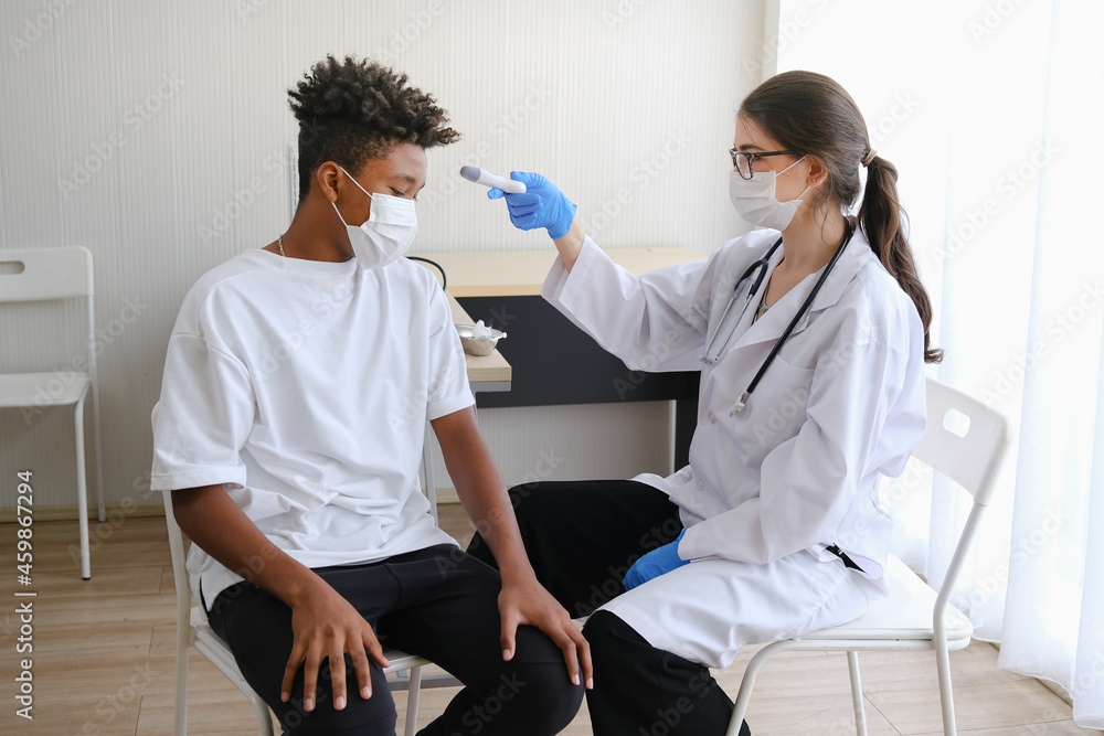 Obraz premium Caucasian doctor woman or nurse giving flu or antiviral vaccine to African American man in hospital or clinic
