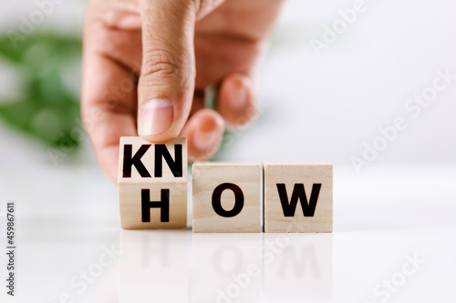 Know how and business concept. Men hand flip cube and changed the word how to know on white table photo