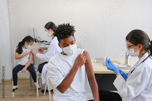 Professional nurse giving flu or antiviral vaccine to people in hospital or clinic or or health center