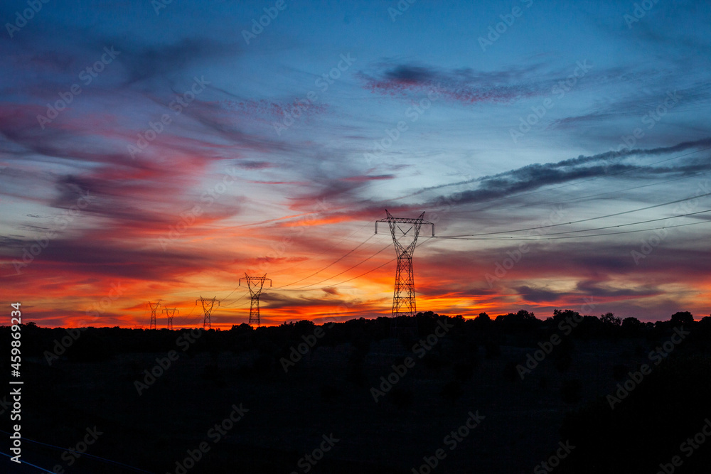 High Voltage Lines, along a highway at sunset.