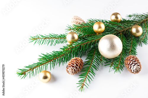 Fir branch, decorated with golden Christmas balls on a white background. Christmas and New Year concept.
